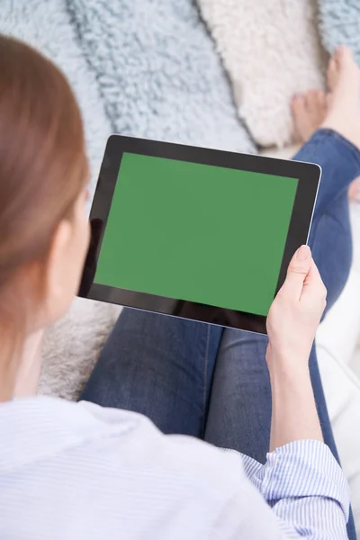 Sopra la spalla vista di donna sdraiata sul divano utilizzando lo schermo verde — Foto Stock