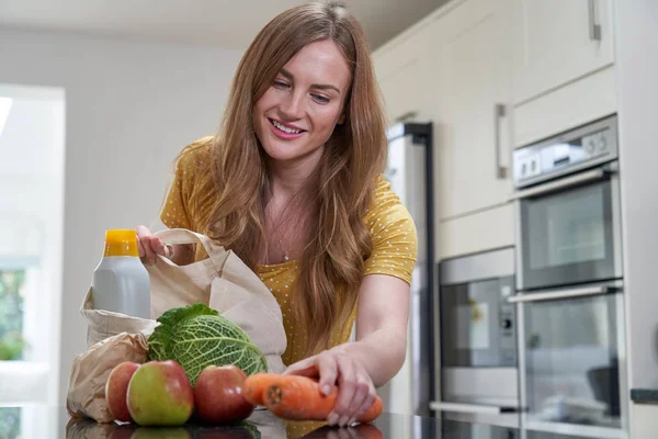 Frau auf dem Heimweg von Einkaufstour packt Plastik frei g aus — Stockfoto