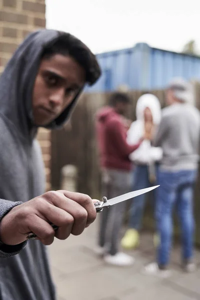Adolescente en banda urbana apuntando cuchillo hacia la cámara — Foto de Stock