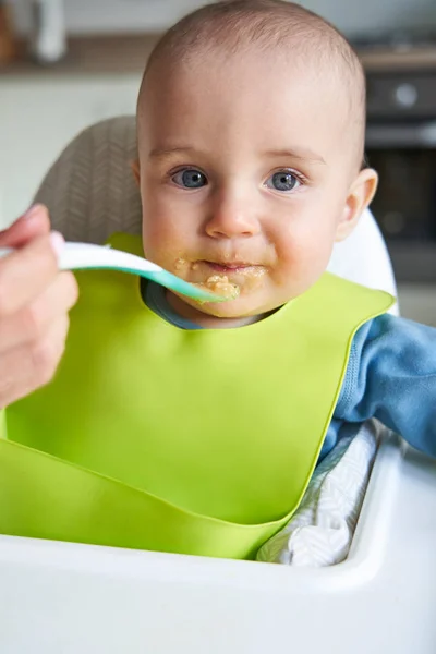 Retrato de bebé sonriente en casa en silla alta siendo alimentado Sol —  Fotos de Stock