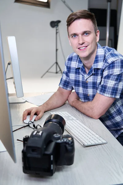 Portrait de photographe masculin en studio examinant des images de Ph — Photo