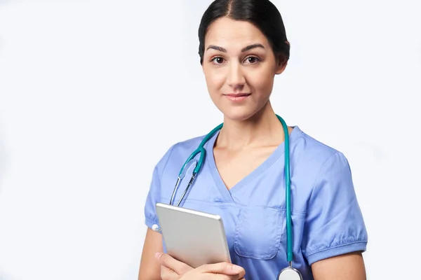 Studio Portrait of Female Nurse Wearing Scrubs Holding Digital T — стоковое фото