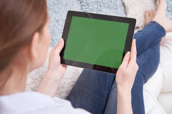 Sopra la spalla vista di donna sdraiata sul divano utilizzando lo schermo verde — Foto Stock