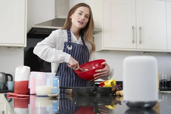 Mujer preparando comida en casa haciendo una pregunta de asistente digital —  Fotos de Stock