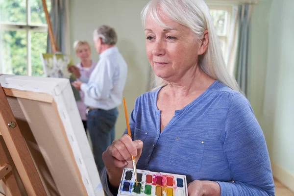 Gruppo di anziani che frequentano corso di pittura con insegnante — Foto Stock