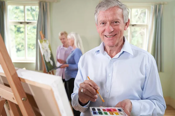 Retrato do homem sênior que assiste à classe da pintura com professor — Fotografia de Stock