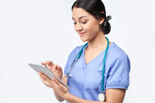 Студия Снимок женщины-медсестры носить Scrubs с помощью цифрового планшета — стоковое фото