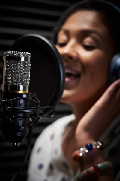 Vocalista femenina usando auriculares cantando en el micrófono en Re — Foto de Stock