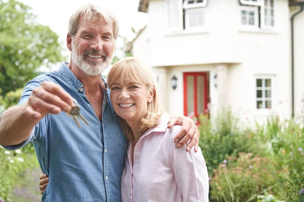 Porträtt av äldre par stående i trädgården framför Dream H — Stockfoto