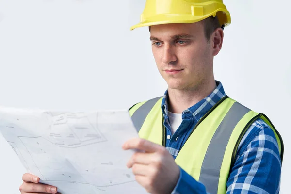 Studio Shot Of Builder Architect Looking At Plans Against White — Stock Photo, Image