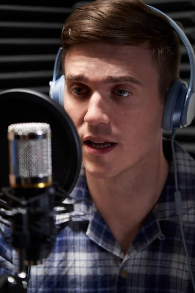 Męski głos nad artystą w studio nagraniowym mówiący do mikrofonu — Zdjęcie stockowe