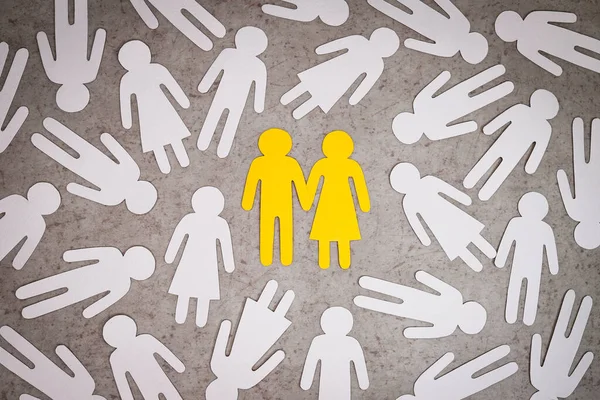 Una pareja enamorada hecha de papel amarillo entre la gente . — Foto de Stock