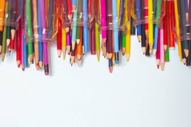 Beyaz arkaplanda gözlüklü renkli kalemler.