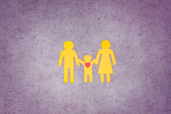 Rodzina z dzieckiem wyciętym z żółtego papieru. Miłość i troska. — Zdjęcie stockowe