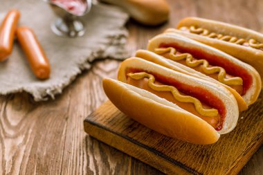 Ketçap ve hardallı üç klasik sosisli sandviç.