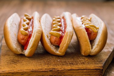 Ketçap ve hardallı üç klasik sosisli sandviç.