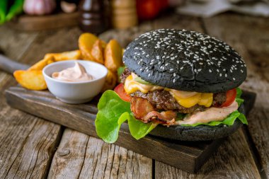 Tahtada etli, peynirli ve pastırmalı Black Burger.