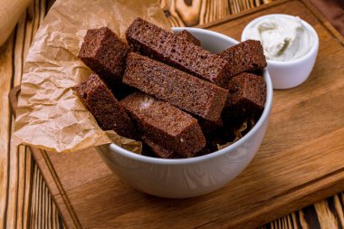 Ahşap tabakta soslu kızarmış sarımsaklı ekmek. 