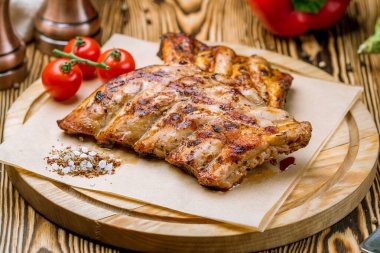 Ahşap tabakta vişneli domatesle kızartılmış domuz pirzolası 