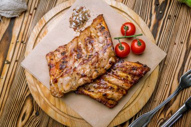 Tahta tabakta sebzelerle kızartılmış domuz pirzolası.