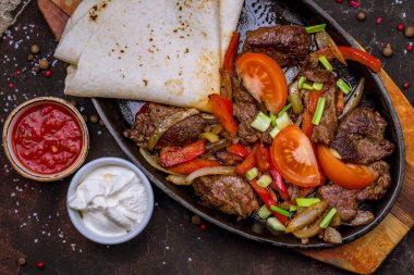 Biftek ve sebzeli bir kap fajita. 