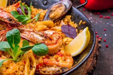 Geleneksel İspanyol paella tavasını deniz ürünleriyle kapatın.
