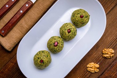 Beyaz tabakta ıspanak topları şeklinde pkhali