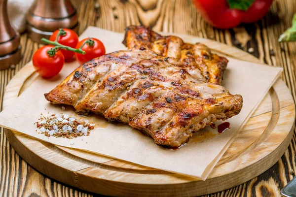 Ahşap tabakta vişneli domatesle kızartılmış domuz pirzolası 