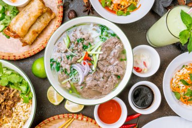 Pho Bo çorbasını arka planda bir çok yemeğin arasında 
