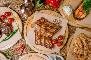 Tahta tabakta sebzelerle kızartılmış domuz pirzolası.