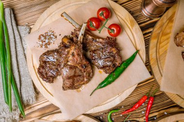 Ahşap tabakta kiraz domatesli kuzu pirzolası 