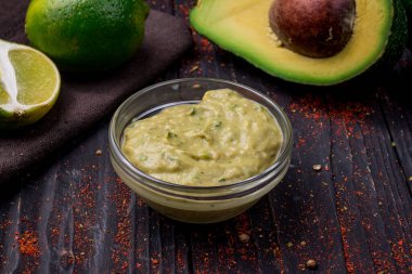 Meksika soslu avokado ve ahşap arka planda limon. 