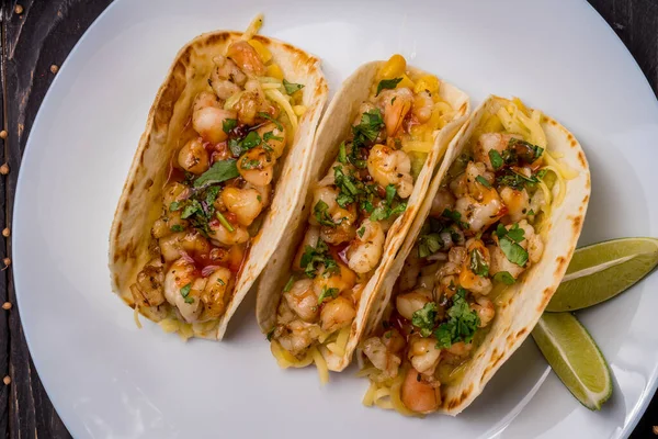 Beyaz tabakta Meksika karidesli taco.