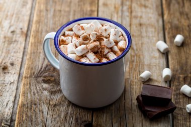 Eski ahşap arka planda lokum olan demir bardakta sıcak çikolata.