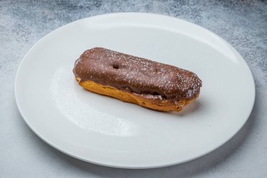 Beyaz bir tabakta çikolatalı ekler.