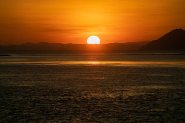 Gün batımları ufukta düz bir daire çiziyor. Büyük güneş. Deniz manzarası. Flores..