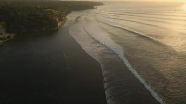 Bali Endonezya 'daki güzel Bingin Sahili üzerinde uçan sinematik yan dron..