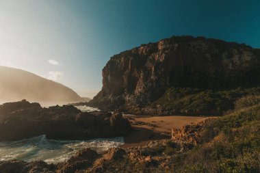 Gün doğumunda plaj ve dağ manzarası. 