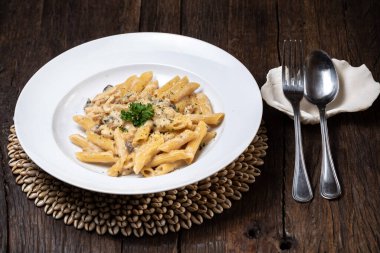 Beyaz mantarlı makarna koyu ahşap masada kremalı soslu porcini.