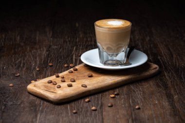 Kahve fincanı ve fasulye eski mutfak masasında sıcak kahve ve sütlü kahve.