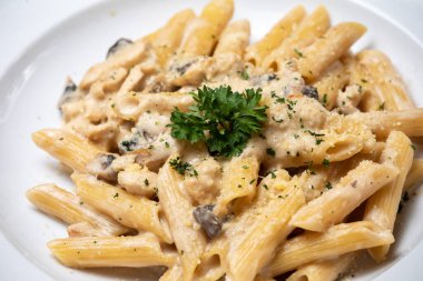 Beyaz mantarlı makarna koyu ahşap masada kremalı soslu porcini.