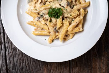 Beyaz mantarlı makarna koyu ahşap masada kremalı soslu porcini.