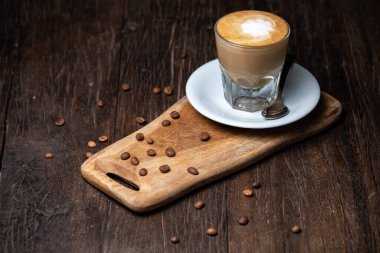 Kahve fincanı ve fasulye eski mutfak masasında sıcak kahve ve sütlü kahve.