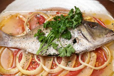 Fırında balık, domates, soğan, sebze. Tam deniz balığı ve sebze.