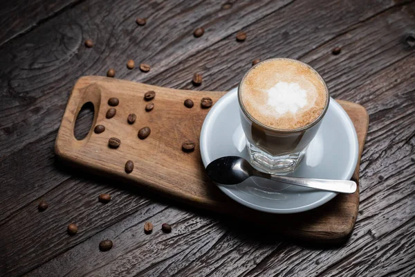 Чашка кофе и бобы на старом кухонном столе Капучино горячий кофе с молочной чашкой — стоковое фото