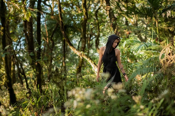 Meisje in een zwarte kap jurk wandelen door het bos, genieten van de wandeling mode — Stockfoto