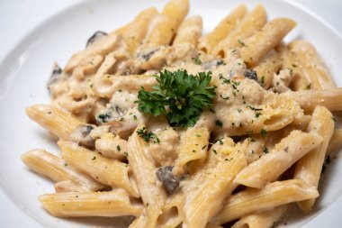 Beyaz mantarlı makarna koyu ahşap masada kremalı soslu porcini.