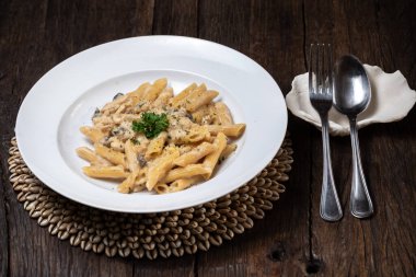 Beyaz mantarlı makarna koyu ahşap masada kremalı soslu porcini.