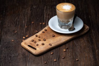 Kahve fincanı ve fasulye eski mutfak masasında sıcak kahve ve sütlü kahve.