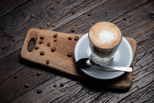 Taza de café y frijoles en la vieja mesa de la cocina Café caliente capuchino con taza de leche — Foto de Stock